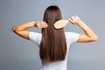 rear-view-of-combing-healthy-long-straight-female-hair-isolated-on-gray.jpg